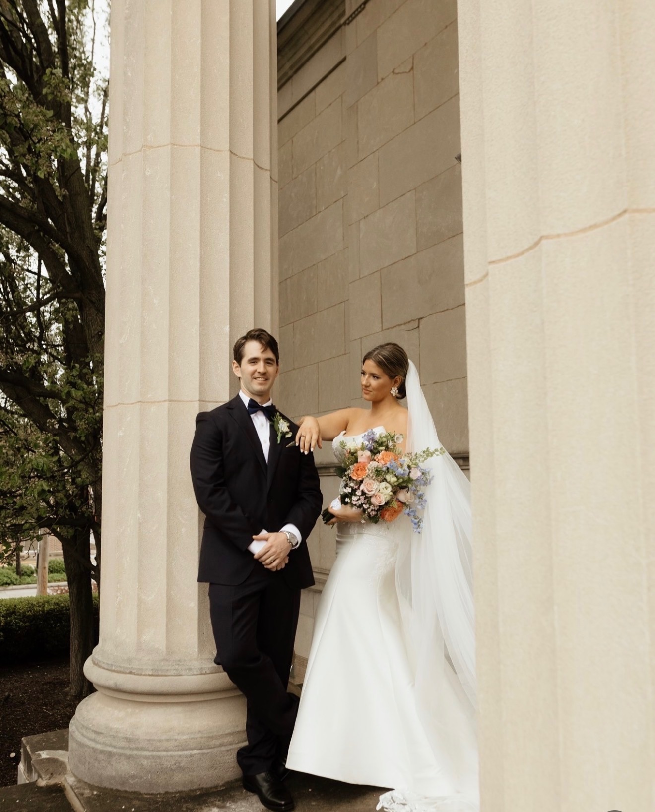 Bride with a veil and soft glam makeup beside her groom on wedding day