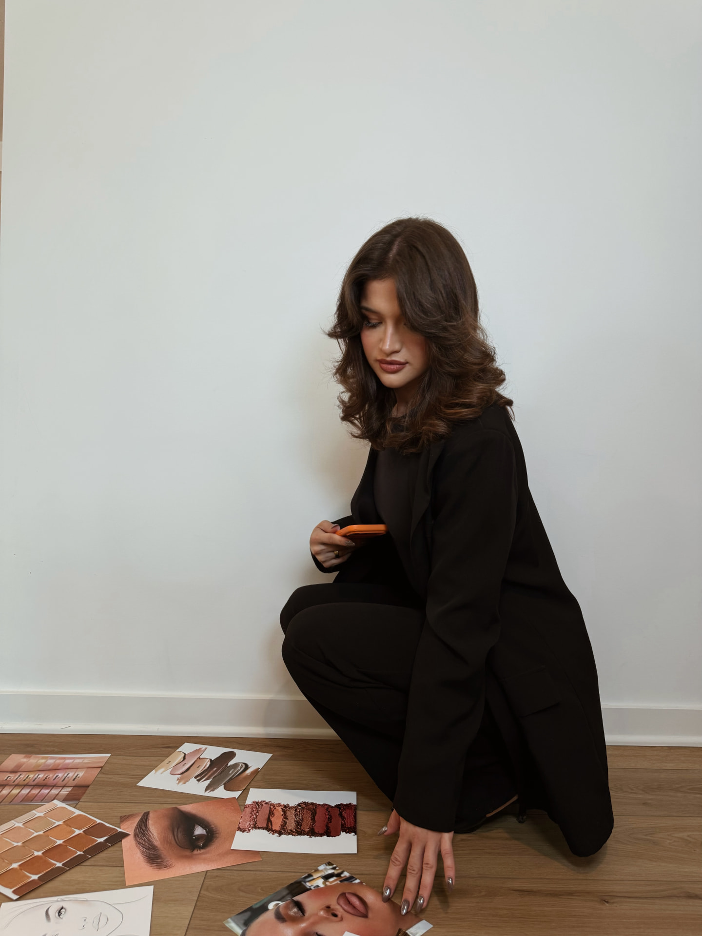Dzenela, Dzenelahasicmua makeup artist, reviewing soft glam makeup reference photos in her studio